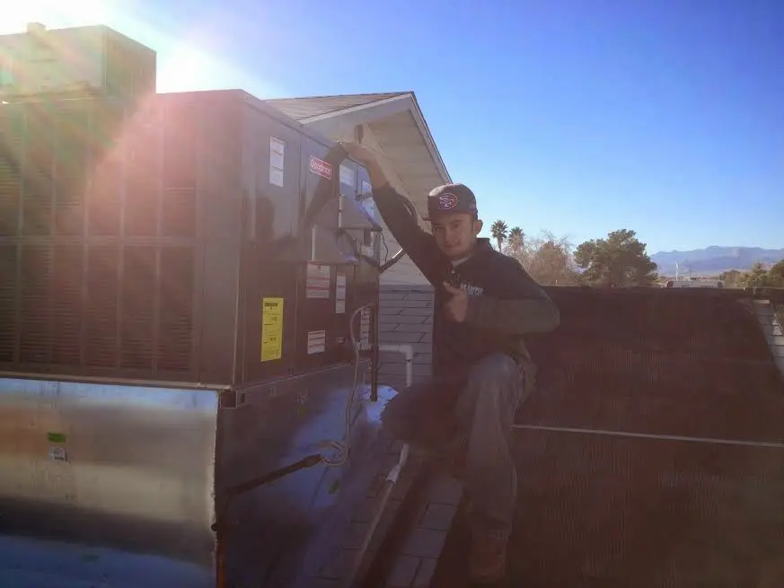 HVAC technician performing AC Tune-Up on a rooftop unit in Kahaluu-Keauhou