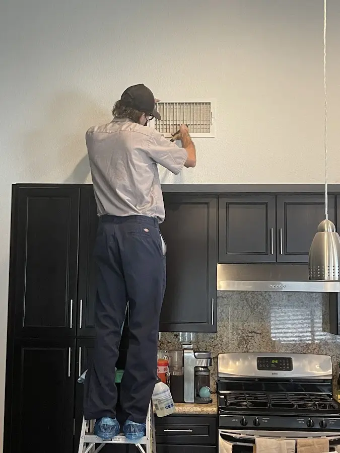 Technician inspecting an air vent during HVAC service in Kahaluu-Keauhou